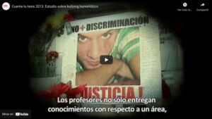 Captura de pantalla de un video titulado "Cuenta tu tesis 2013: Estudio sobre bullying homofóbico". Muestra una imagen de una persona y un texto que dice "NO + DISCRIMINACIÓN" y "JUSTICIA", junto con subtítulos que dicen "Los profesores no sólo entregan conocimientos con respecto a un área".