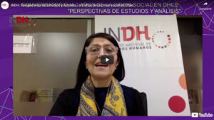 Mujer con gafas hablando en un video de YouTube, con un cartel del Instituto Nacional de Derechos Humanos de Chile al fondo.