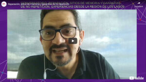 Imagen de un hombre con gafas y auriculares participando en un conversatorio en línea titulado "Reparación, sitios de memoria y garantías de no repetición" en YouTube, organizado por INDH.