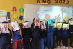 Niños en un aula mostrando dibujos de osos.