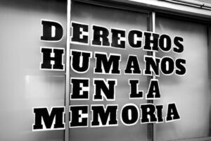 Cartel en blanco y negro que dice "DERECHOS HUMANOS EN LA MEMORIA".